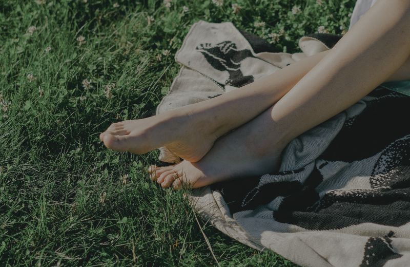 Bare feet resting on a wool blanket in long summer grass, the slow pace of a weekend spent walking in the Lake District